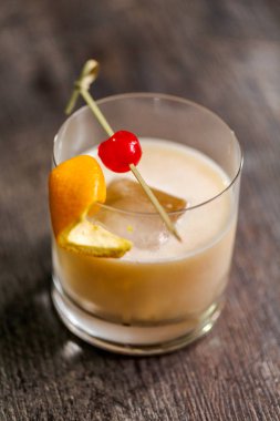 Viski kokteyli kokteyl portakal ve vişne ile süslenmiş.