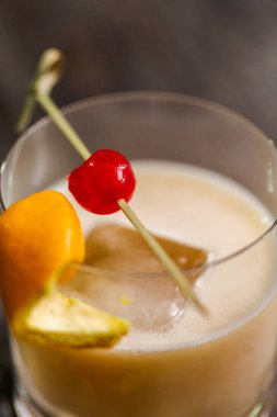 Viski kokteyli kokteyl portakal ve vişne ile süslenmiş.