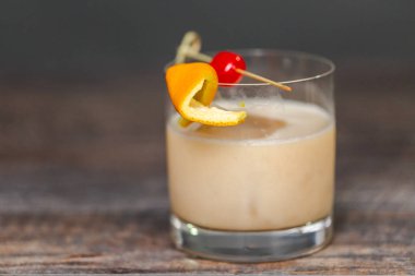 Viski kokteyli kokteyl portakal ve vişne ile süslenmiş.