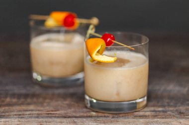 Viski kokteyli kokteyl portakal ve vişne ile süslenmiş.