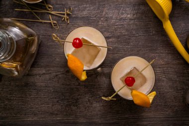 Viski kokteyli kokteyl portakal ve vişne ile süslenmiş.