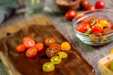 Hatıra cherry domates ahşap kesme tahtası üzerinde Dilimleme.