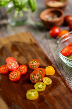 Hatıra cherry domates ahşap kesme tahtası üzerinde Dilimleme.