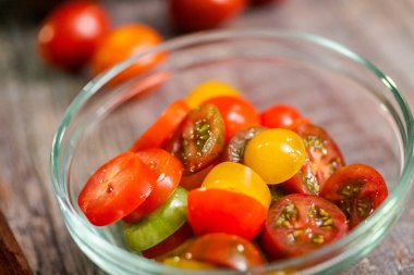 Hatıra cherry domates ahşap kesme tahtası üzerinde Dilimleme.