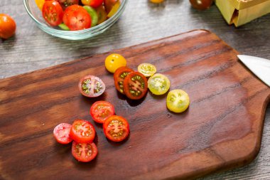Hatıra cherry domates ahşap kesme tahtası üzerinde Dilimleme.