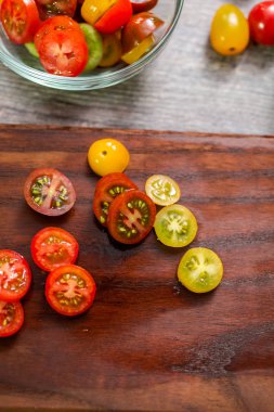 Hatıra cherry domates ahşap kesme tahtası üzerinde Dilimleme.
