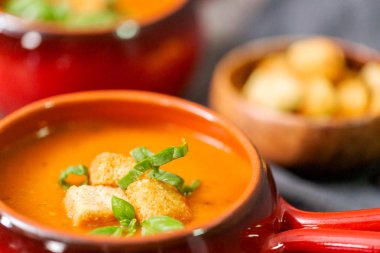 Taze fesleğen ve kruton ile kavrulmuş domates çorbası.