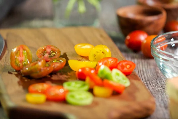 Hatıra cherry domates ahşap kesme tahtası üzerinde Dilimleme.