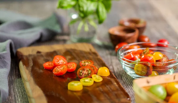 Hatıra cherry domates ahşap kesme tahtası üzerinde Dilimleme.