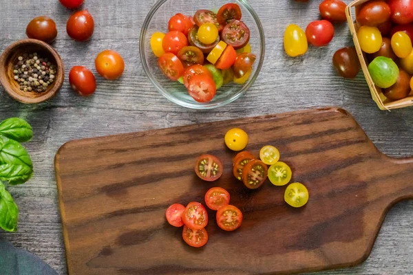 Hatıra cherry domates ahşap kesme tahtası üzerinde Dilimleme.