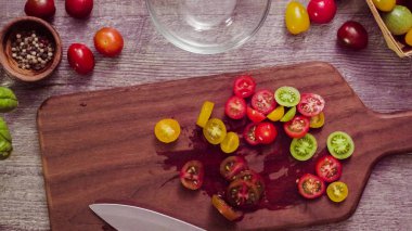 Adım adım. Hatıra cherry domates ahşap kesme tahtası üzerinde Dilimleme.