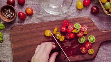 Adım adım. Hatıra cherry domates ahşap kesme tahtası üzerinde Dilimleme.