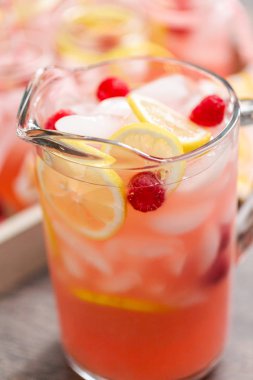 Frambuazlı limonata taze limon ve cam sürahi içinde ahududu ile süslenmiş.