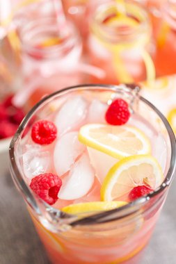 Frambuazlı limonata taze limon ve cam sürahi içinde ahududu ile süslenmiş.