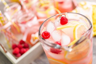 Frambuazlı limonata taze limon ve cam sürahi içinde ahududu ile süslenmiş.