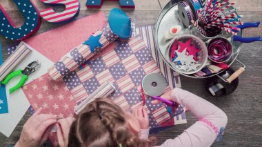 Anne ve kızı kağıt havai fişek yapma ileri geri 4 Temmuz kutlamaları.