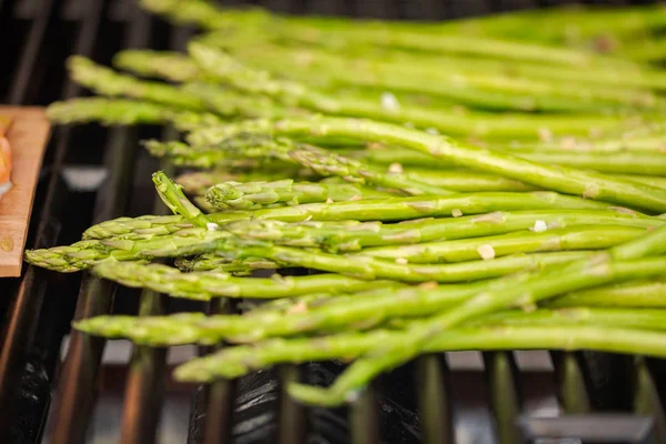 Grilling fresh asparagus on outdoor gas grill.