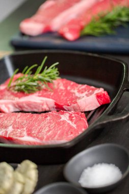 Dökme demir tavada ham New York şerit biftek.