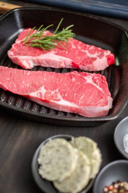 Dökme demir tavada ham New York şerit biftek.