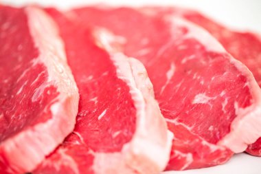 Beyaz bir arka plan üzerinde ham New York şerit biftek.