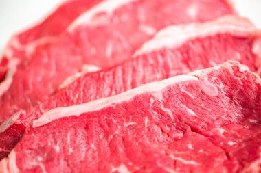 Beyaz bir arka plan üzerinde ham New York şerit biftek.