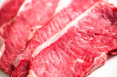 Beyaz bir arka plan üzerinde ham New York şerit biftek.