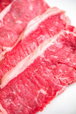 Beyaz bir arka plan üzerinde ham New York şerit biftek.