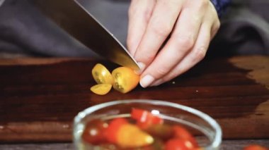 Hatıra cherry domates ahşap kesme tahtası üzerinde Dilimleme.