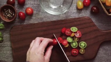 Hatıra cherry domates ahşap kesme tahtası üzerinde Dilimleme.