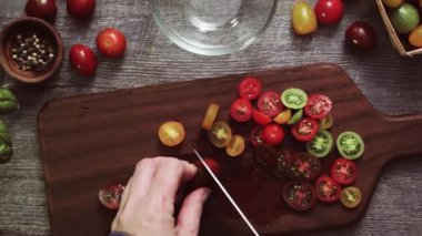 Hatıra cherry domates ahşap kesme tahtası üzerinde Dilimleme.