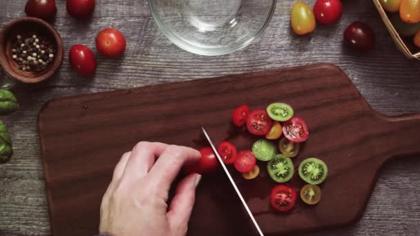 木製のまな板に先祖伝来のチェリー トマトをスライス — ストック動画