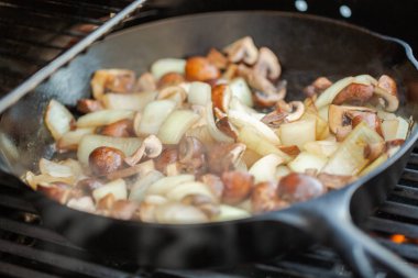Adım adım. Izgara mantar ve soğan dökme demir tavada açık gaz ızgara.