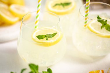 Taze limonata ile süslenmiş bir içme bardaklarda limon ve nane dilimlenmiş.