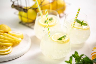 Taze limonata ile süslenmiş bir içme bardaklarda limon ve nane dilimlenmiş.
