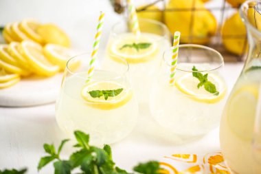 Taze limonata ile süslenmiş bir içme bardaklarda limon ve nane dilimlenmiş.