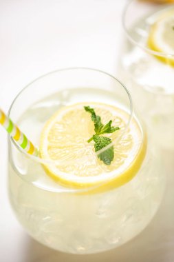 Taze limonata ile süslenmiş bir içme bardaklarda limon ve nane dilimlenmiş.