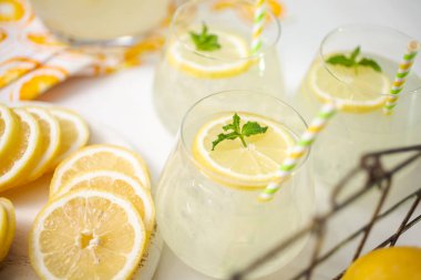 Taze limonata ile süslenmiş bir içme bardaklarda limon ve nane dilimlenmiş.