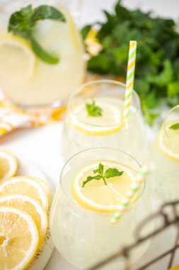 Taze limonata ile süslenmiş bir içme bardaklarda limon ve nane dilimlenmiş.