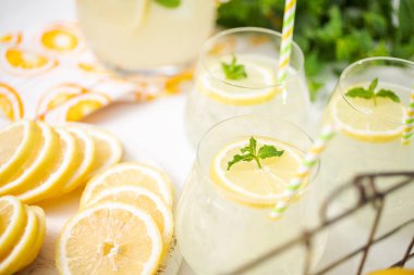 Taze limonata ile süslenmiş bir içme bardaklarda limon ve nane dilimlenmiş.