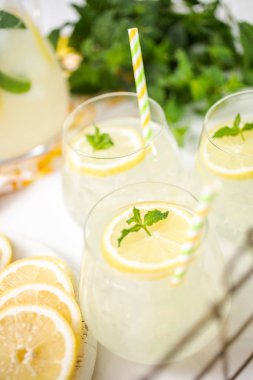 Taze limonata ile süslenmiş bir içme bardaklarda limon ve nane dilimlenmiş.