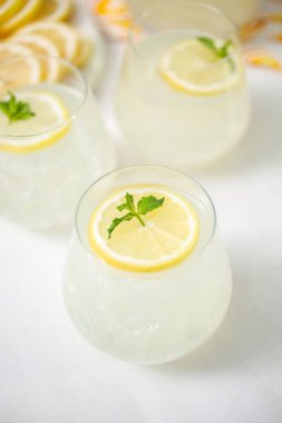 Taze limonata ile süslenmiş bir içme bardaklarda limon ve nane dilimlenmiş.