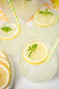 Taze limonata ile süslenmiş bir içme bardaklarda limon ve nane dilimlenmiş.