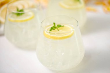 Taze limonata ile süslenmiş bir içme bardaklarda limon ve nane dilimlenmiş.