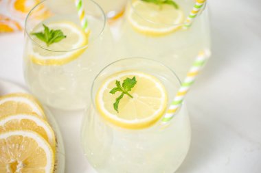Taze limonata ile süslenmiş bir içme bardaklarda limon ve nane dilimlenmiş.