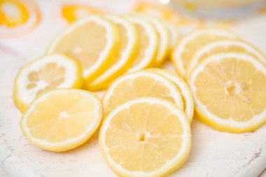 Beyaz ahşap kesme tahtası üzerinde taze dilimlenmiş limon.