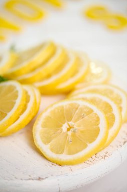 Beyaz ahşap kesme tahtası üzerinde taze dilimlenmiş limon.