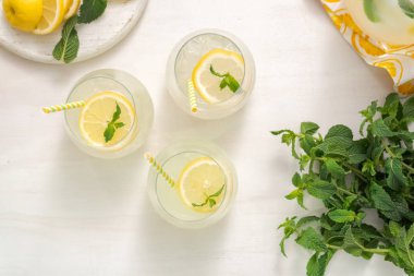 Taze limonata ile süslenmiş bir içme bardaklarda limon ve nane dilimlenmiş.