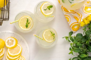 Taze limonata ile süslenmiş bir içme bardaklarda limon ve nane dilimlenmiş.