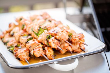 Adım adım. Tavuk yakitori açık gaz ızgara yanındaki bir beyaz metal servis tepsi.