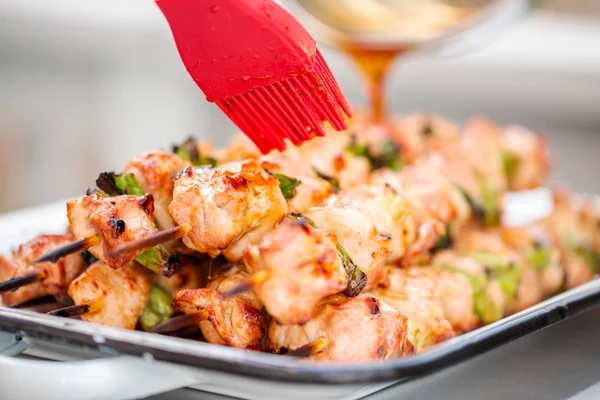 stock image Step by step. Glazing chicken yakitori on bamboo skewers with pastry brush.